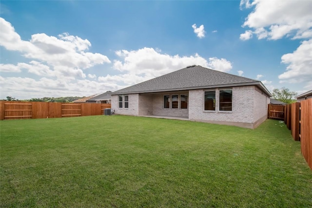 544 Tekoa Dr, Georgetown, TX 78628 - rear view of property featuring central air condition unit, a lawn, a fenced backyard, and brick siding