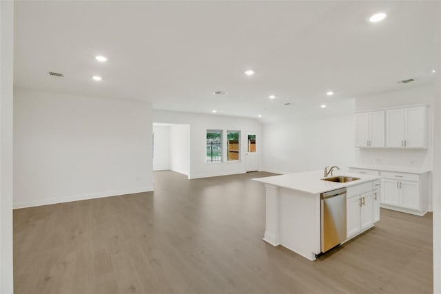 kitchen featuring stainless steel dishwasher, recessed lighting, open floor plan, and a sink
