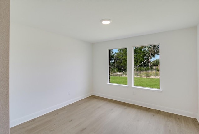 unfurnished room featuring baseboards and light wood-style flooring