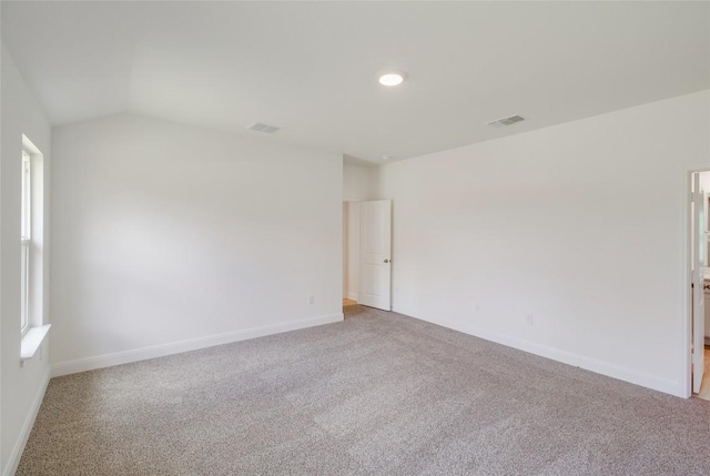 spare room with baseboards, a wealth of natural light, carpet, and lofted ceiling