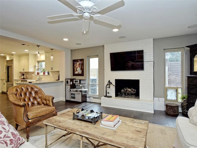 306 Briarwood Trl, Austin, TX 78746 - living area featuring plenty of natural light, dark wood-style flooring, a ceiling fan, and a brick fireplace