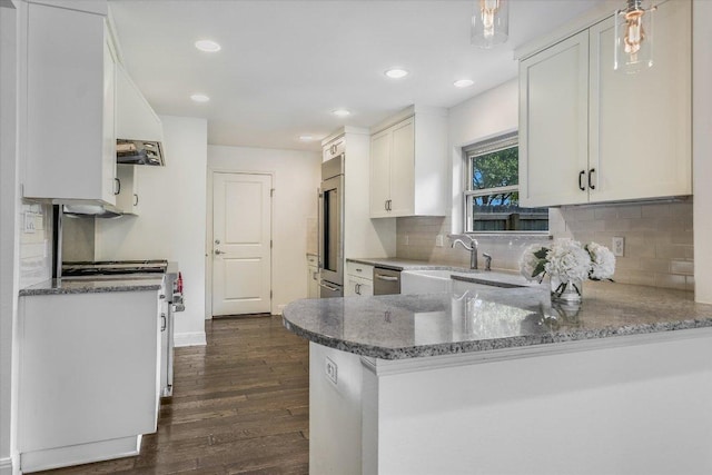 306 Briarwood Trl, Austin, TX 78746 - kitchen with premium appliances, a peninsula, dark wood finished floors, and white cabinets