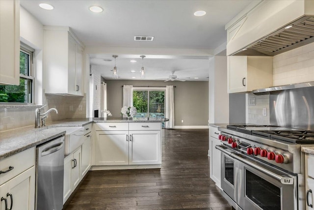 306 Briarwood Trl, Austin, TX 78746 - kitchen featuring a peninsula, wall chimney range hood, visible vents, dark wood-style flooring, and appliances with stainless steel finishes
