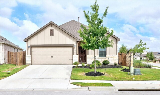 200 Isabella Way, Liberty Hill, TX 78642 - view of front facade with board and batten siding, stone siding, concrete driveway, an attached garage, and roof with shingles