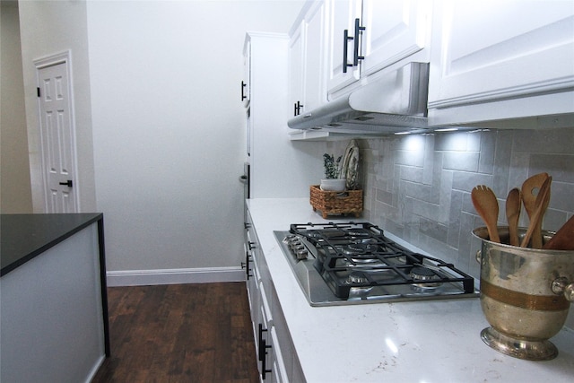 kitchen featuring backsplash, stainless steel gas cooktop, dark wood finished floors, baseboards, and white cabinetry