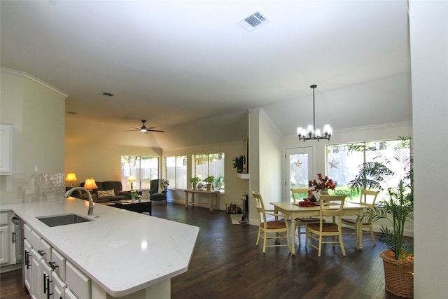 kitchen with visible vents, ornamental molding, a sink, dark wood finished floors, and ceiling fan with notable chandelier