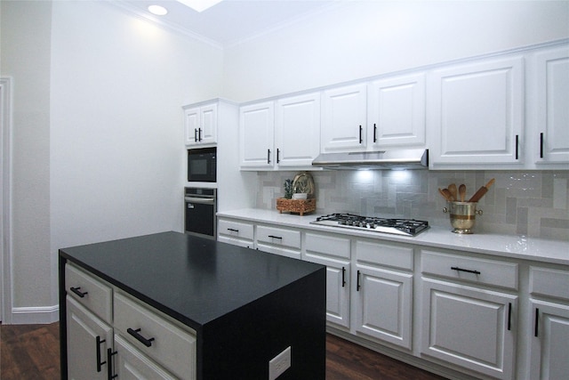kitchen with crown molding, stainless steel appliances, tasteful backsplash, and under cabinet range hood