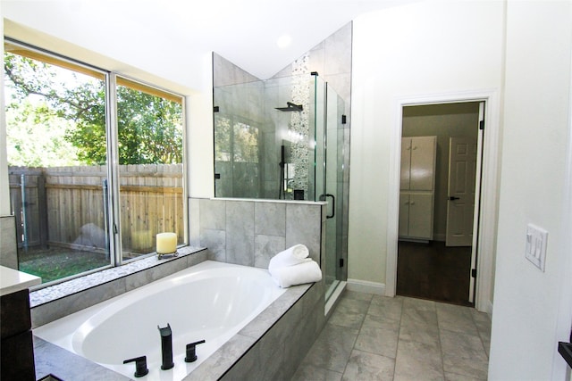 full bath featuring a bath, lofted ceiling, and a shower stall