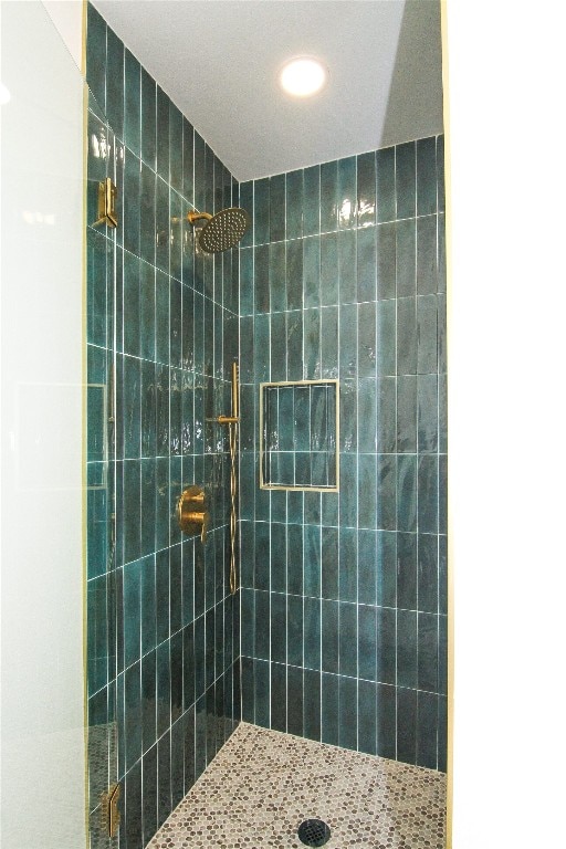 full bathroom with a tile shower and recessed lighting
