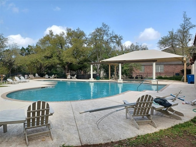 pool with a gazebo, fence, and a patio