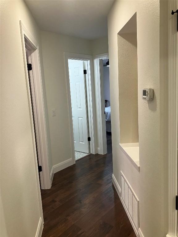 8102 Davis Mountain Pass, Austin, TX 78726 - hall with dark wood-style flooring and baseboards