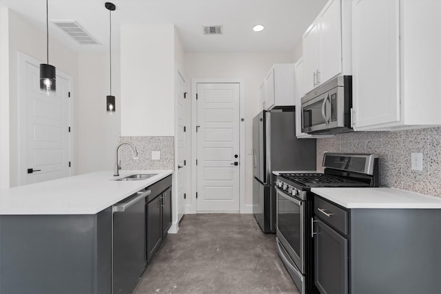 900 Banister Ln Unit D, Austin, TX 78704 - kitchen featuring stainless steel appliances, a peninsula, finished concrete floors, tasteful backsplash, and white cabinets