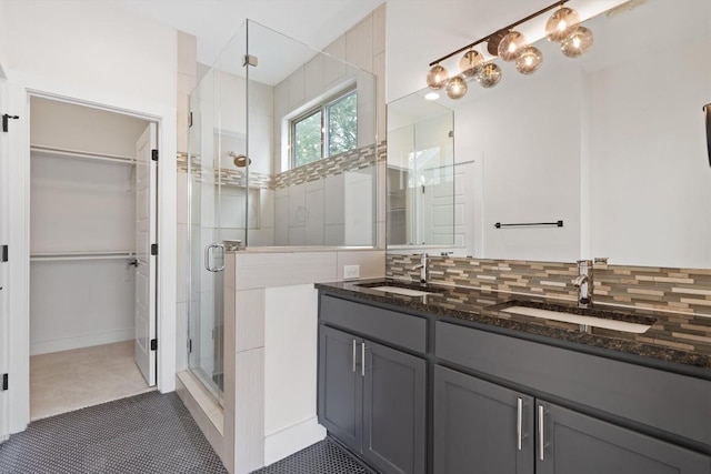 900 Banister Ln Unit D, Austin, TX 78704 - bathroom with a shower stall, double vanity, a walk in closet, and decorative backsplash