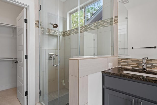 900 Banister Ln Unit D, Austin, TX 78704 - bathroom featuring a shower stall, a walk in closet, vanity, and backsplash