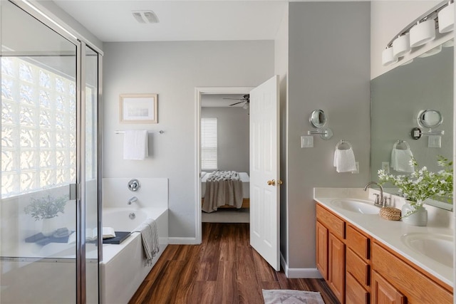 3100 Lynnbrook Dr, Austin, TX 78748 - ensuite bathroom featuring a garden tub, wood finished floors, double vanity, a shower stall, and ceiling fan