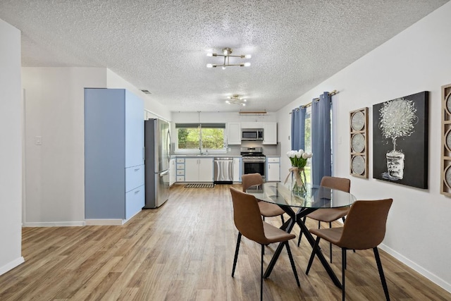 5304 Harvest Ln, Austin, TX 78745 - dining area featuring a textured ceiling, light wood-style flooring, and baseboards