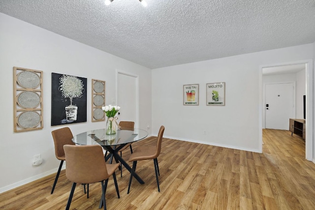 5304 Harvest Ln, Austin, TX 78745 - dining room with light wood-style flooring, a textured ceiling, and baseboards