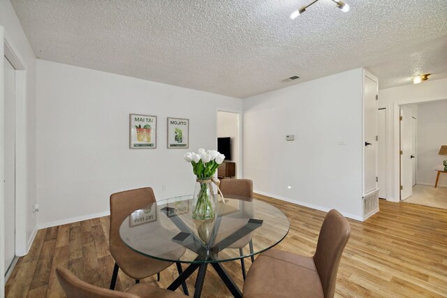 5304 Harvest Ln, Austin, TX 78745 - dining area with light wood-style floors and a textured ceiling