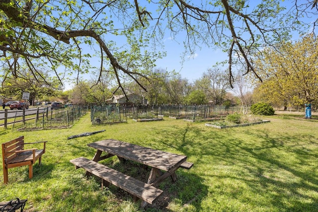 view of property's community featuring fence, a garden, and a yard