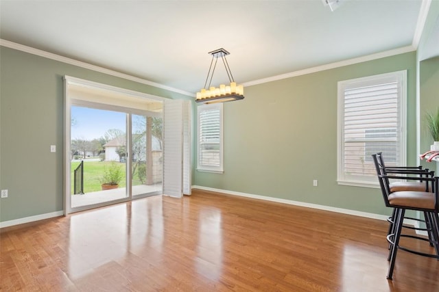 111 Belfalls Dr, Georgetown, TX 78633 - unfurnished dining area featuring crown molding, baseboards, wood finished floors, and a chandelier