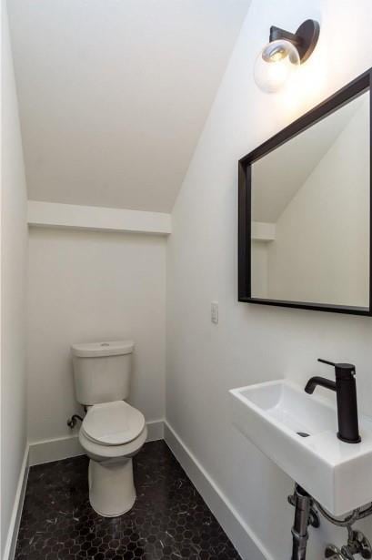 504 Normandy St Unit A, Austin, TX 78745 - bathroom with toilet, baseboards, lofted ceiling, and a sink