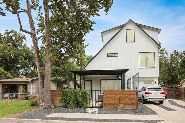 504 Normandy St Unit A, Austin, TX 78745 - view of front facade with driveway, board and batten siding, a fenced front yard, and a garage
