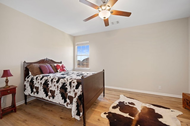 7901 SW Pkwy Unit 21, Austin, TX 78735 - bedroom featuring wood finished floors, baseboards, and a ceiling fan