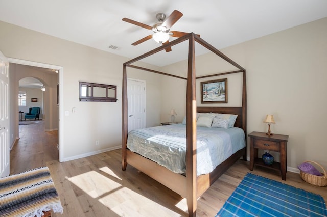 7901 SW Pkwy Unit 21, Austin, TX 78735 - bedroom with arched walkways, light wood-type flooring, baseboards, and a ceiling fan