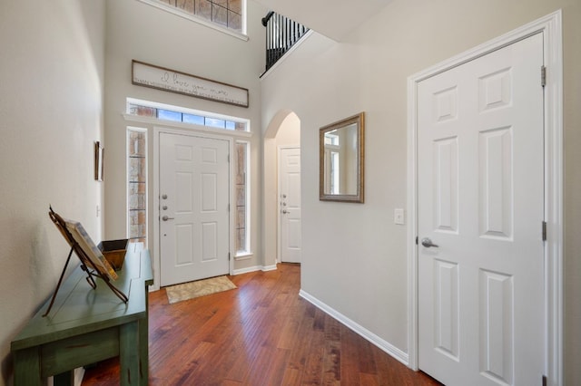 7901 SW Pkwy Unit 21, Austin, TX 78735 - foyer featuring arched walkways, baseboards, dark wood-style floors, and a high ceiling