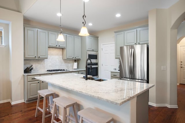 7901 SW Pkwy Unit 21, Austin, TX 78735 - kitchen featuring appliances with stainless steel finishes, arched walkways, a sink, baseboards, and decorative backsplash