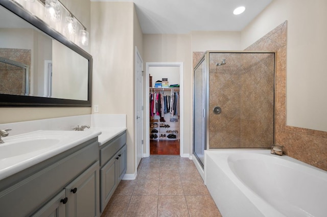 7901 SW Pkwy Unit 21, Austin, TX 78735 - bathroom featuring a shower stall, vanity, a garden tub, tile patterned floors, and a spacious closet
