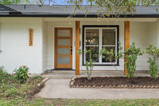 1113 Plymouth Dr, Austin, TX 78758 - property entrance featuring a porch, brick siding, and roof with shingles
