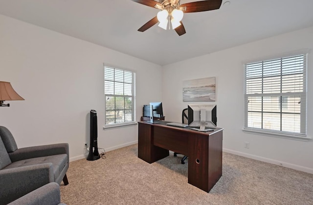 carpeted office space featuring baseboards and ceiling fan