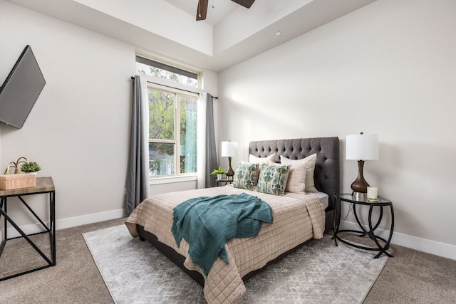 carpeted bedroom with baseboards, ceiling fan, and a towering ceiling