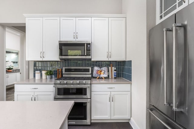 kitchen featuring decorative backsplash, stainless steel appliances, and white cabinets