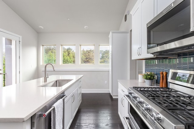 kitchen featuring a sink, light countertops, baseboards, stainless steel appliances, and dark wood-type flooring