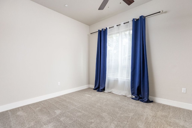 carpeted empty room with baseboards and a ceiling fan