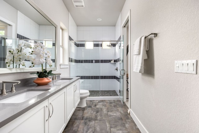 bathroom featuring a sink, a textured wall, toilet, and visible vents