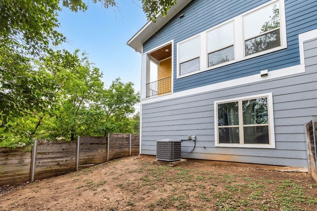 view of side of property with fence and cooling unit