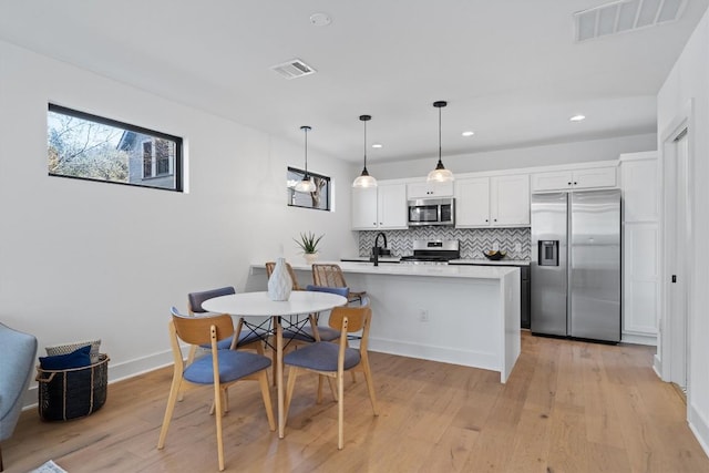 2102 Eva St Unit 2, Austin, TX 78704 - kitchen with stainless steel appliances, tasteful backsplash, recessed lighting, a peninsula, and light wood-style flooring
