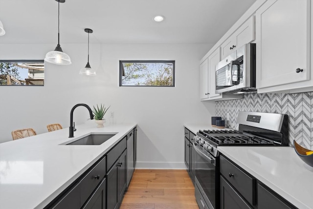 2102 Eva St Unit 2, Austin, TX 78704 - kitchen with stainless steel appliances, light countertops, light wood finished floors, white cabinetry, and recessed lighting