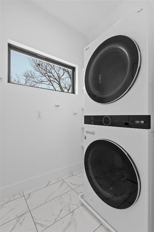 2102 Eva St Unit 2, Austin, TX 78704 - washroom with stacked washer / dryer and marble finish floors