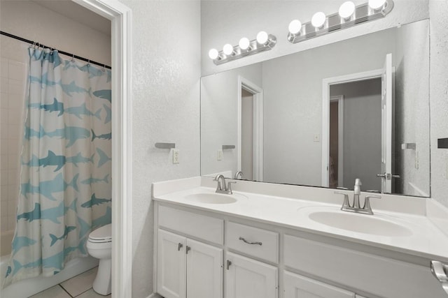full bath with tile patterned flooring, double vanity, toilet, and a sink