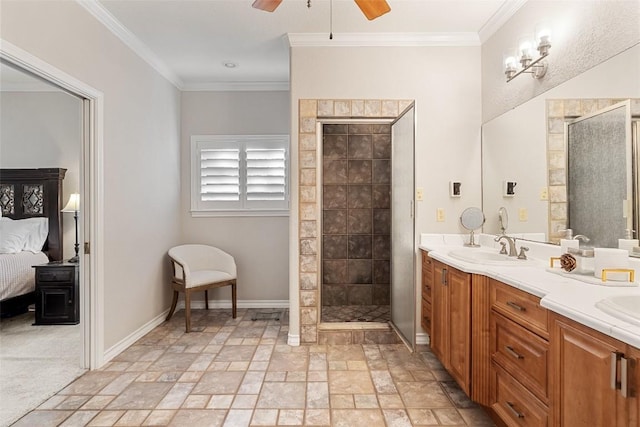 ensuite bathroom featuring stone tile flooring, a ceiling fan, a stall shower, and a sink