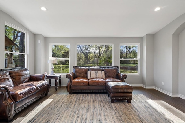 living area with wood finished floors, arched walkways, and recessed lighting