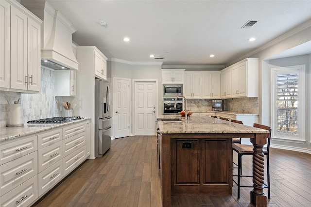 kitchen featuring premium range hood, visible vents, dark wood-type flooring, and stainless steel appliances