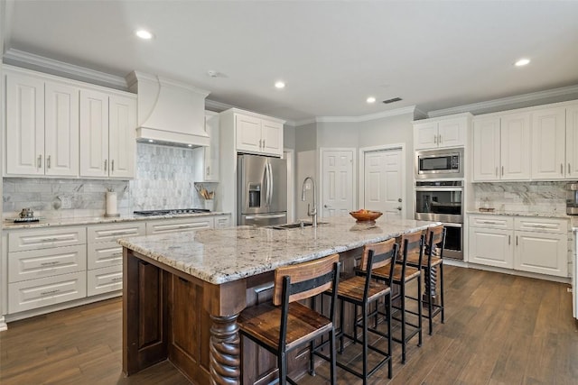 kitchen featuring a sink, decorative backsplash, appliances with stainless steel finishes, premium range hood, and ornamental molding