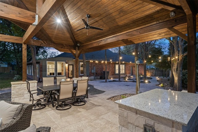 view of patio / terrace with a fenced backyard, a ceiling fan, outdoor dry bar, and outdoor dining space