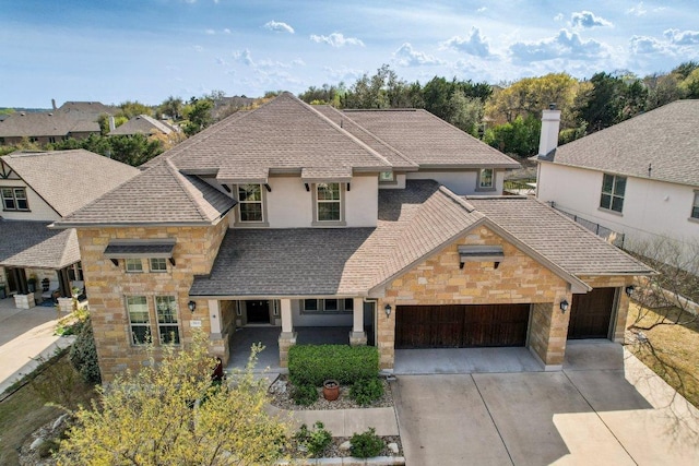 3501 Venezia Vw, Leander, TX 78641 - view of front facade with stone siding, a garage, concrete driveway, and a shingled roof