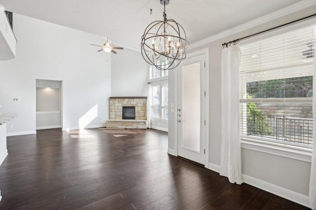 3501 Venezia Vw, Leander, TX 78641 - unfurnished living room featuring a fireplace, ceiling fan, baseboards, dark wood-style flooring, and a chandelier